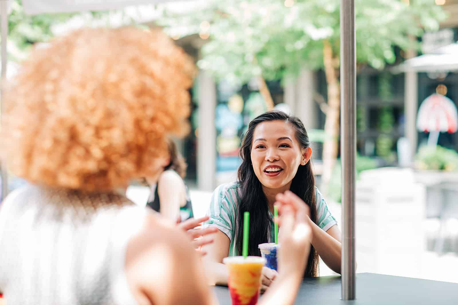 Friends chatting outdoors with milkshakes