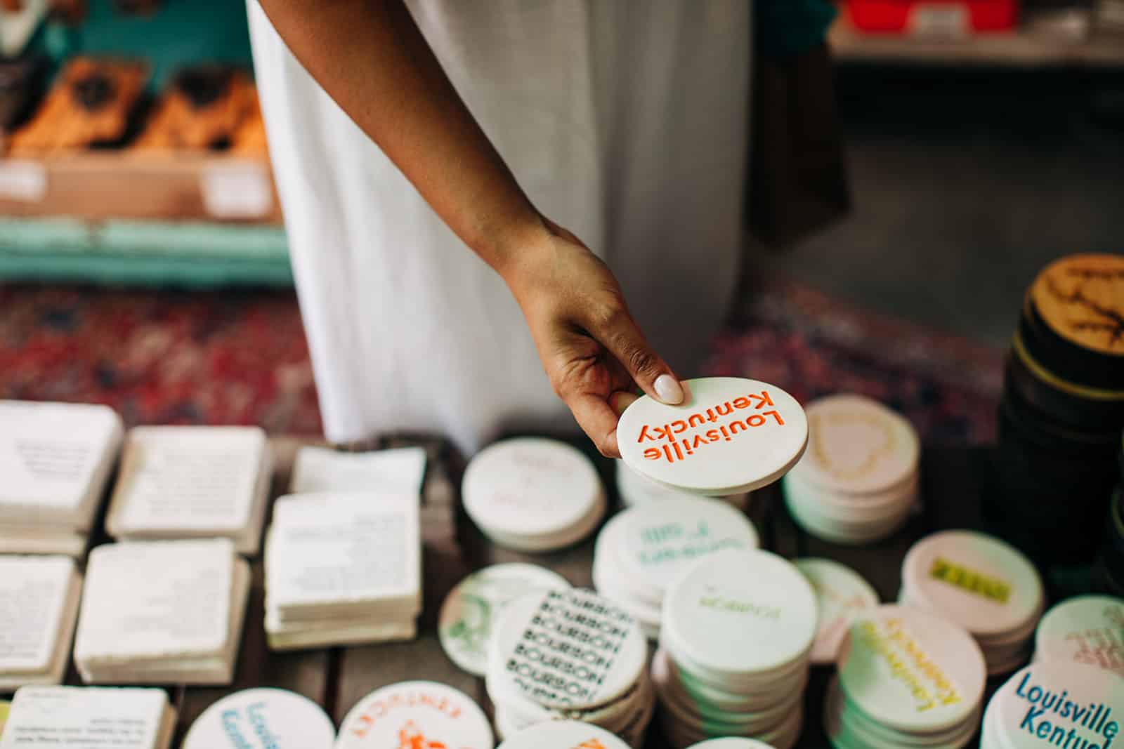 Woman holding coasters with text